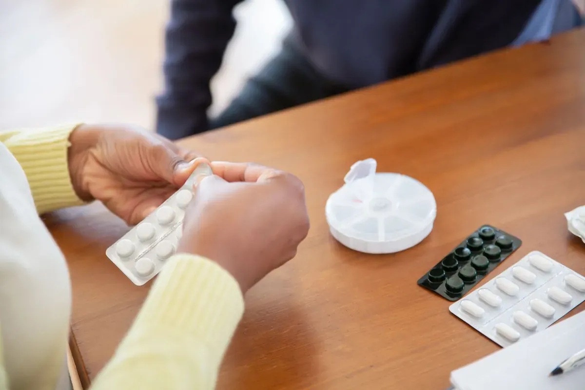 在桌上分装铝箔板包装药品的双手
